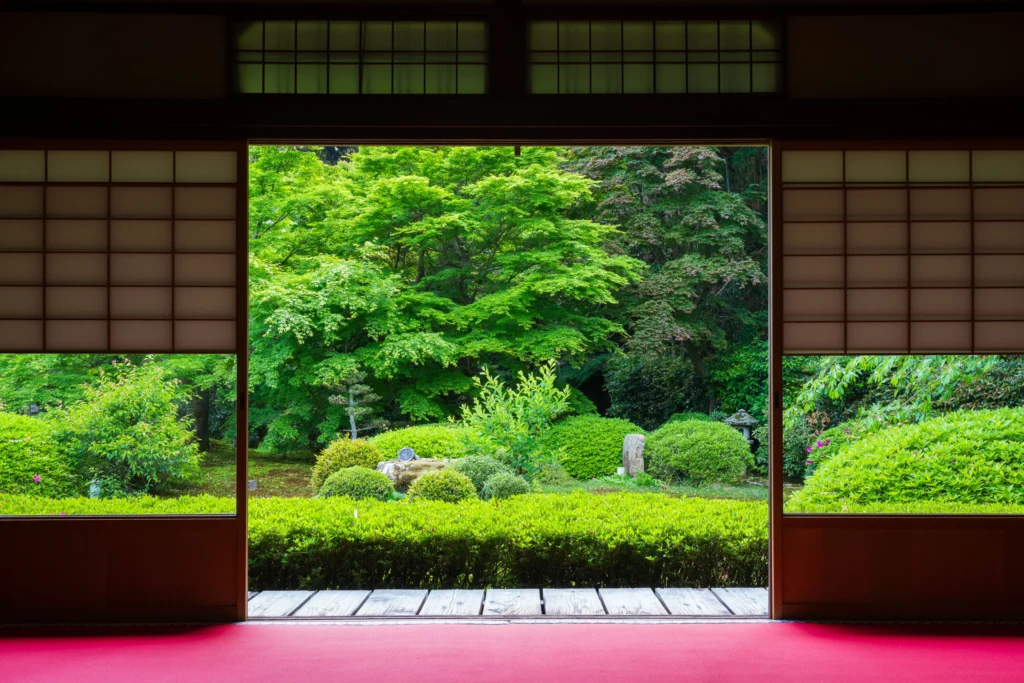 Traditional Japanese temple lodging corridor with shoji screens overlooking misty morning garden