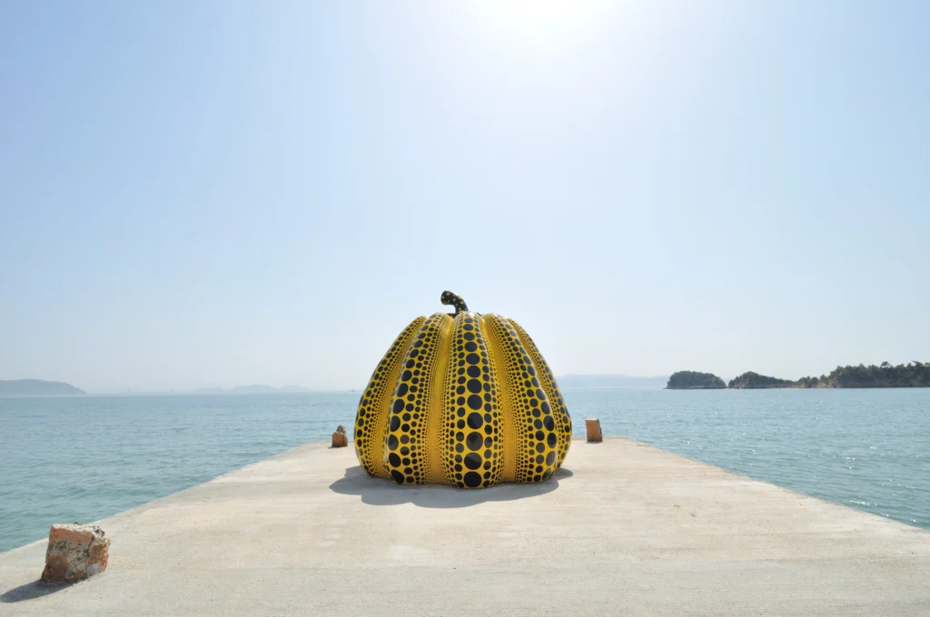 Naoshima art island Japan yellow Yayoi Kusama pumpkin sculpture on pier with Seto Inland Sea