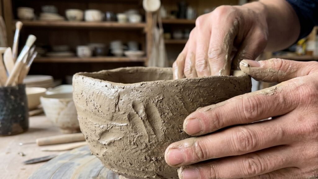 Raku pottery hand-forming tezukune technique showing finger impressions in clay creating traditional Japanese tea bowl