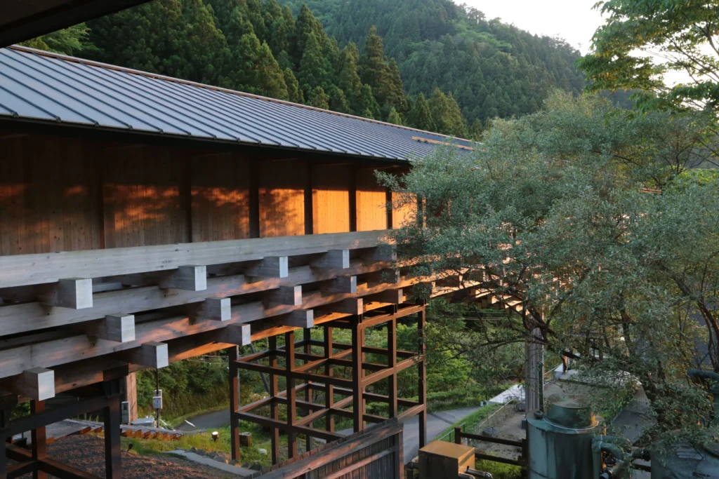 The wooden exterior of Kumo-no-Ue-no-Hotel (Hotel Above the Clouds) by Kengo Kuma, blending into the misty mountains of Yusuhara.